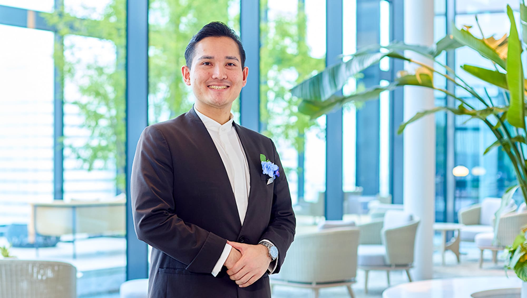 手を前に組み、姿勢正しく立っている佐藤さん
